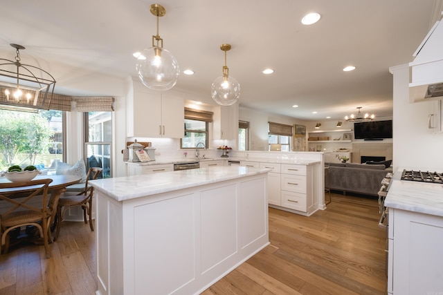 7 Shawbridge Ln, Little Rock, AR 72212 - kitchen with open floor plan, a chandelier, a peninsula, white cabinetry, and light wood-style flooring