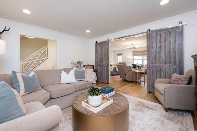 7 Shawbridge Ln, Little Rock, AR 72212 - living room featuring a barn door, wood finished floors, crown molding, recessed lighting, and stairs