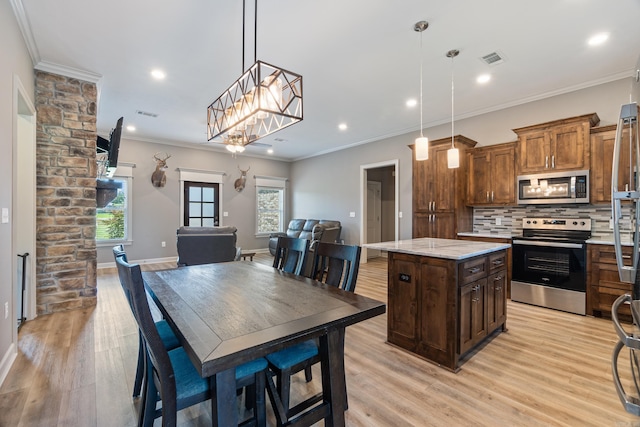 26 Edward Way, Greenbrier, AR 72058 - kitchen featuring stainless steel appliances, tasteful backsplash, light wood-style floors, a kitchen island, and hanging light fixtures