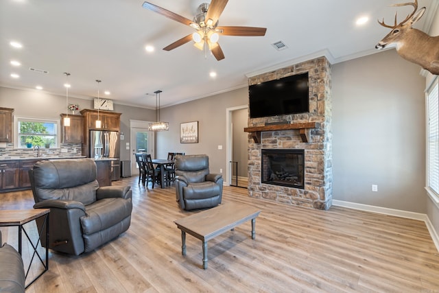 26 Edward Way, Greenbrier, AR 72058 - living room featuring a ceiling fan, light wood finished floors, a stone fireplace, ornamental molding, and recessed lighting