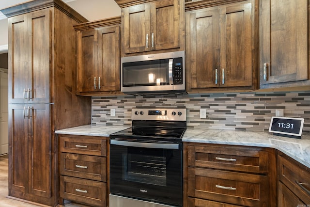 26 Edward Way, Greenbrier, AR 72058 - kitchen featuring stainless steel microwave, electric stove, backsplash, and light stone counters