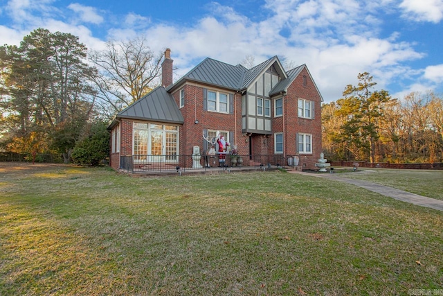 301 W Magnolia St, Rison, AR 71665 - view of front of property featuring a chimney, a standing seam roof, brick siding, a front lawn, and a metal roof