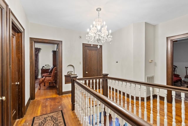 301 W Magnolia St, Rison, AR 71665 - hallway with an upstairs landing, light wood-type flooring, and a chandelier