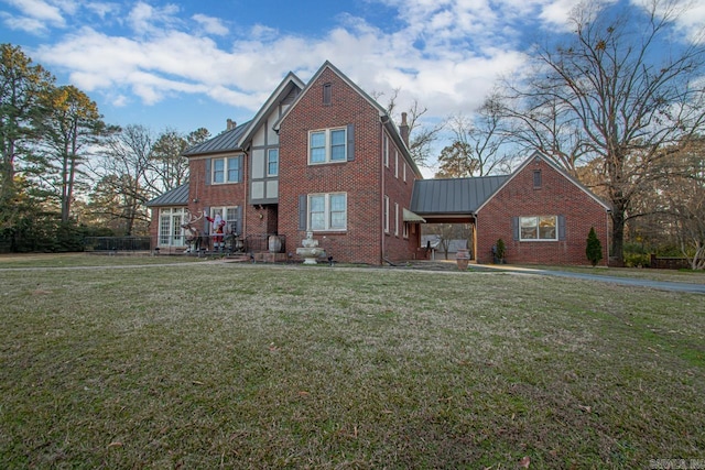 301 W Magnolia St, Rison, AR 71665 - tudor home featuring a standing seam roof, brick siding, a metal roof, and a front lawn