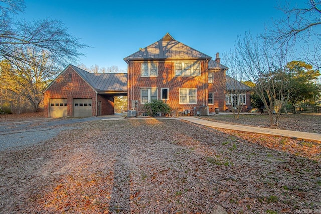 301 W Magnolia St, Rison, AR 71665 - view of front of home with a chimney, brick siding, an attached garage, a metal roof, and gravel driveway