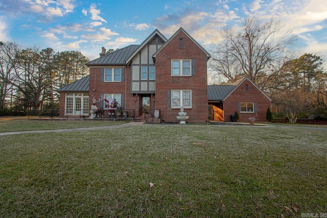 301 W Magnolia St, Rison, AR 71665 - english style home with a standing seam roof, a metal roof, a front lawn, brick siding, and a chimney