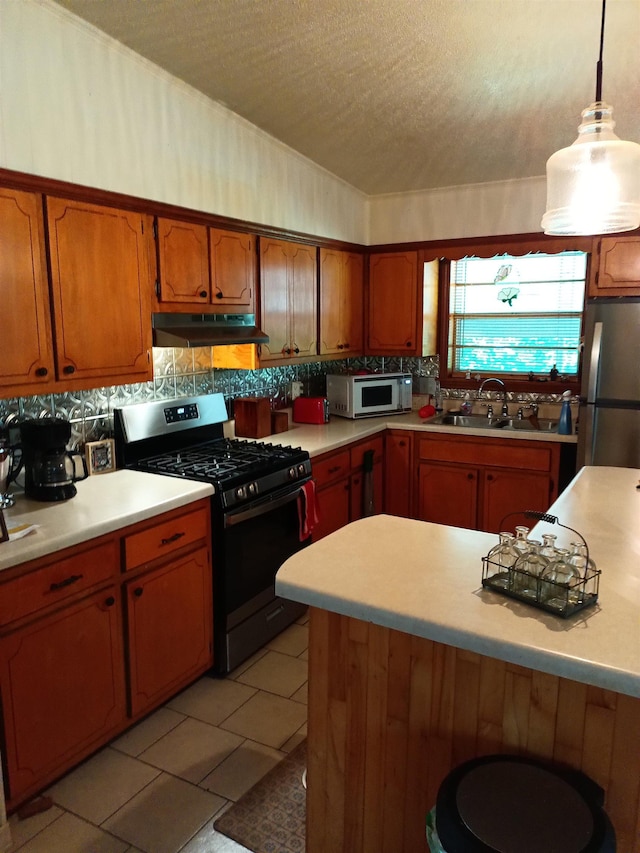 203 Diamond Ln, Horseshoe Bend, AR 72512 - kitchen featuring stainless steel appliances, under cabinet range hood, a textured ceiling, light countertops, and brown cabinetry