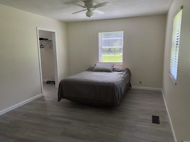 4 Trout, Heber Springs, AR 72543 - bedroom with wood finished floors, a textured ceiling, a walk in closet, and a ceiling fan
