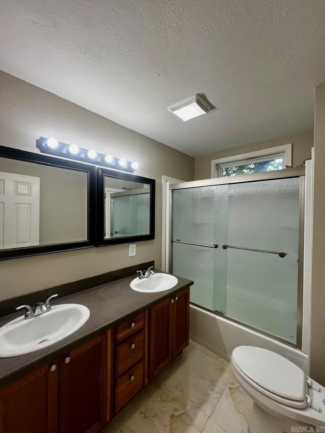 809 Banner St, Benton, AR 72015 - bathroom featuring double vanity, shower / bath combination with glass door, and a textured ceiling
