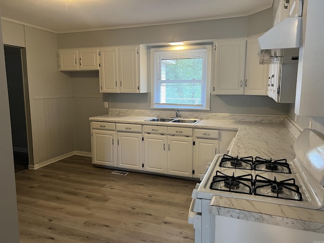 8713 Westwood Ave, Little Rock, AR 72204 - kitchen with white gas stove, ornamental molding, white cabinets, light countertops, and wood finished floors