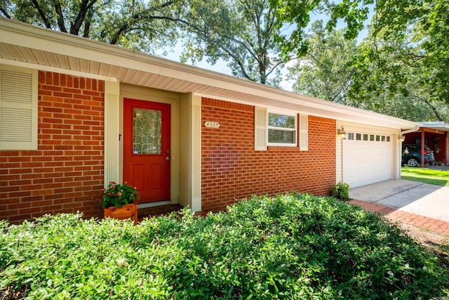 4509 Crestline Dr, North Little Rock, AR 72116 - view of exterior entry with brick siding, a garage, and concrete driveway