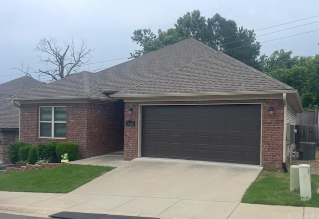 ranch-style house featuring a garage, brick siding, driveway, and roof with shingles