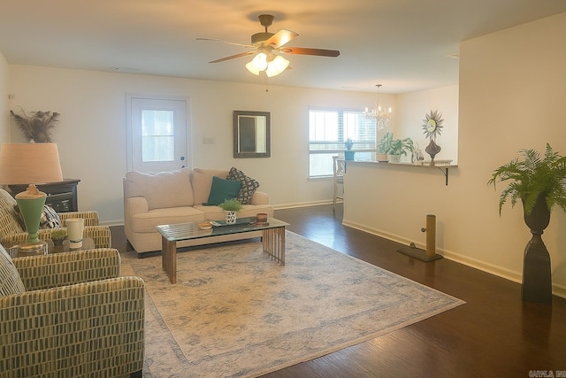 living area featuring dark wood-style floors, a ceiling fan, and a chandelier