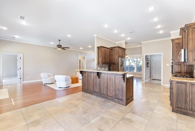 205 Lucia Ln, North Little Rock, AR 72113 - kitchen with ornamental molding, a breakfast bar area, ceiling fan, a peninsula, and light tile patterned flooring