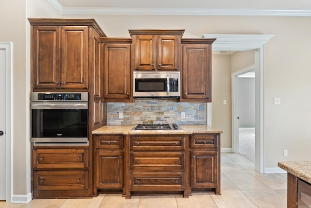 205 Lucia Ln, North Little Rock, AR 72113 - kitchen with stainless steel appliances, backsplash, light stone counters, light tile patterned flooring, and ornamental molding