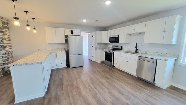 705 Liberty, Marked Tree, AR 72365 - kitchen with stainless steel appliances, a peninsula, light wood-style floors, light stone countertops, and recessed lighting