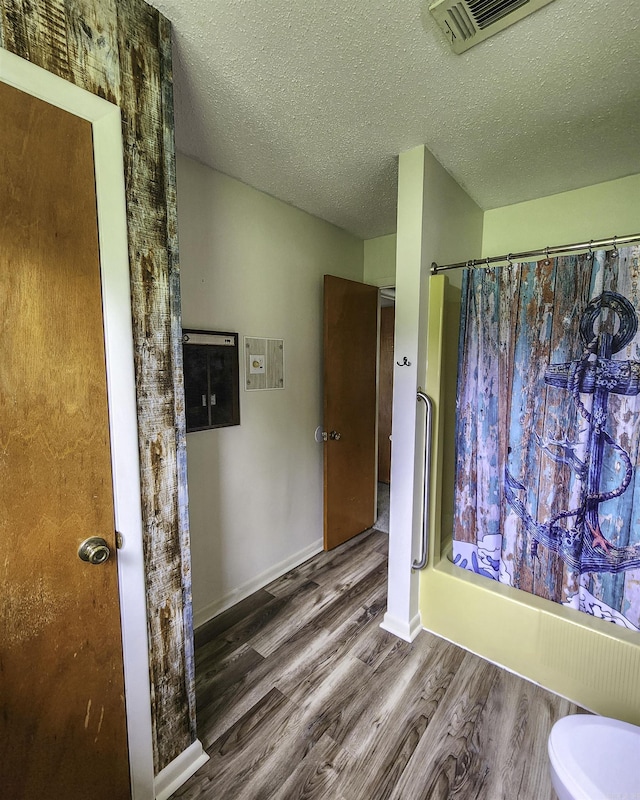 7309 Faulkner Lake Rd, North Little Rock, AR 72117 - full bathroom featuring wood finished floors, a textured ceiling, and a shower with shower curtain