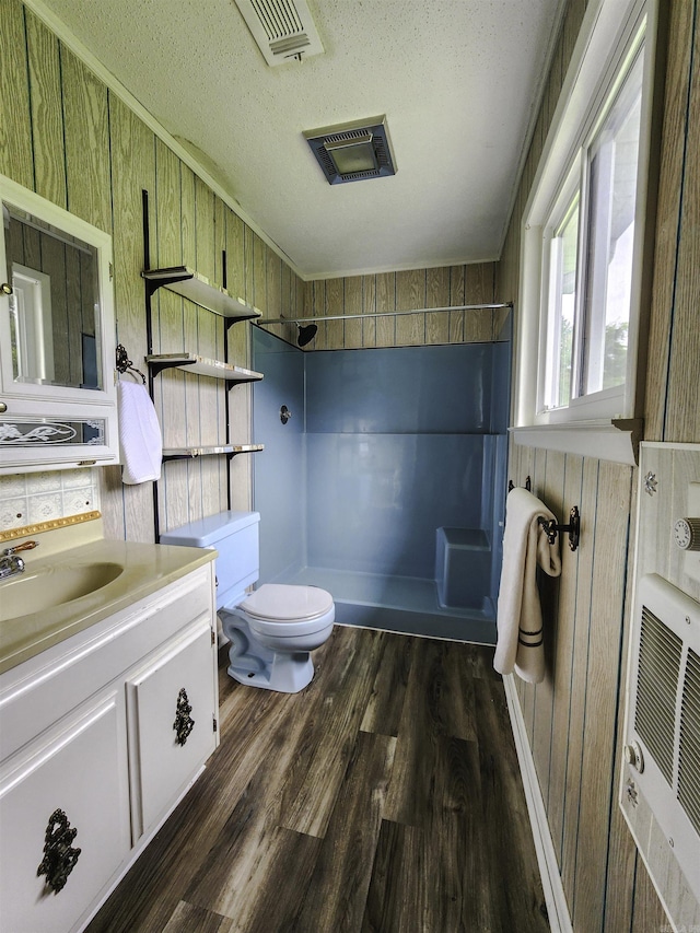 7309 Faulkner Lake Rd, North Little Rock, AR 72117 - bathroom with tiled shower, vanity, wood finished floors, a textured ceiling, and wooden walls