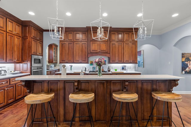 203 Miramar Blvd, Little Rock, AR 72223 - kitchen with arched walkways, appliances with stainless steel finishes, backsplash, a spacious island, and crown molding