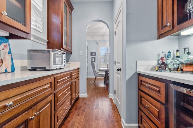 203 Miramar Blvd, Little Rock, AR 72223 - bar featuring wine cooler, arched walkways, dark wood finished floors, and ornamental molding