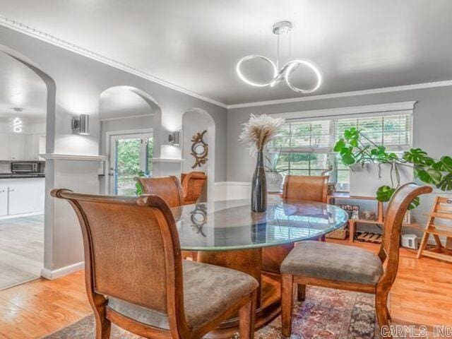 22 Nob Hill Cv, Little Rock, AR 72205 - dining room with a chandelier, ornamental molding, wood finished floors, and arched walkways