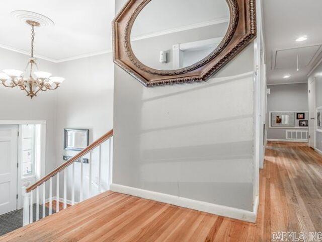22 Nob Hill Cv, Little Rock, AR 72205 - corridor featuring attic access, ornamental molding, a chandelier, wood finished floors, and an upstairs landing