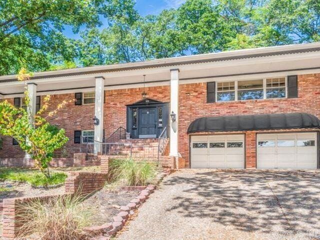 22 Nob Hill Cv, Little Rock, AR 72205 - raised ranch featuring an attached garage, driveway, and brick siding