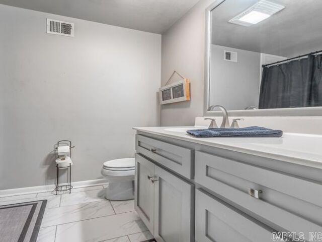 22 Nob Hill Cv, Little Rock, AR 72205 - full bathroom featuring marble look tile flooring, vanity, and curtained shower