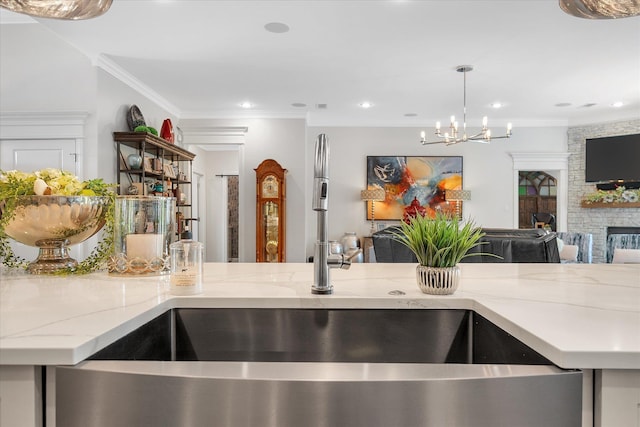 4260 Weldon Cv, Jonesboro, AR 72404 - kitchen featuring open floor plan, light stone countertops, a chandelier, crown molding, and a stone fireplace