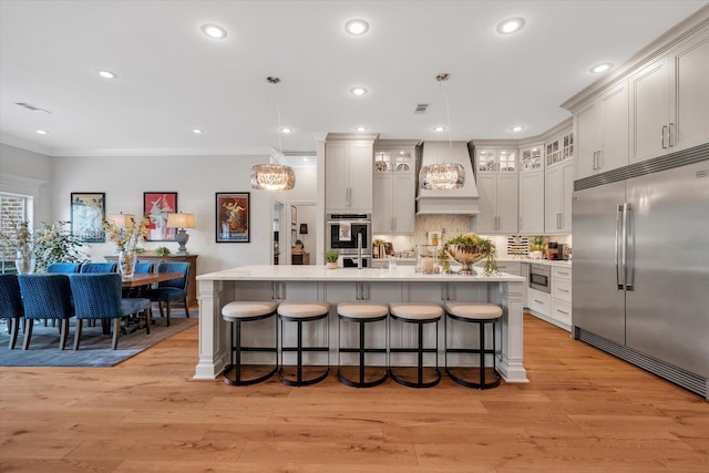 4260 Weldon Cv, Jonesboro, AR 72404 - kitchen with built in appliances, custom exhaust hood, a breakfast bar, light countertops, and crown molding