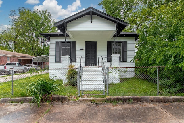 2708 Rock St, Little Rock, AR 72206 - shotgun-style home featuring a fenced front yard, a gate, covered porch, and a carport