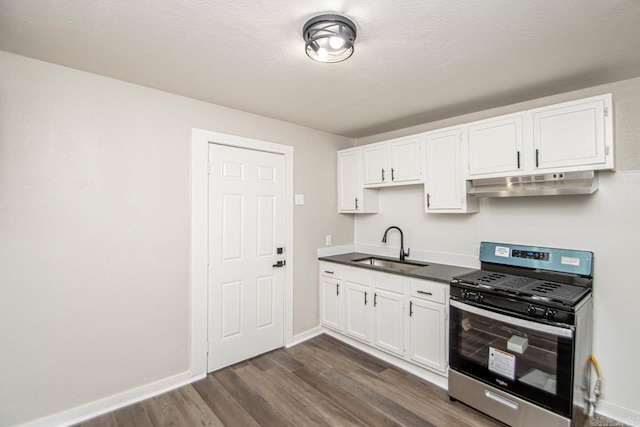 2708 Rock St, Little Rock, AR 72206 - kitchen featuring stainless steel gas range, under cabinet range hood, dark wood-style floors, and white cabinetry