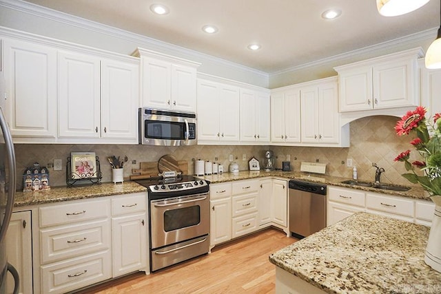 29 Taylor Park Loop, Little Rock, AR 72211 - kitchen featuring stainless steel appliances, white cabinetry, light wood-type flooring, light stone countertops, and ornamental molding