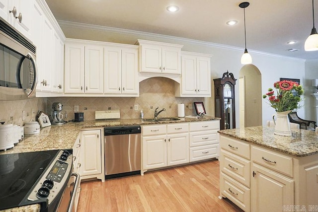 29 Taylor Park Loop, Little Rock, AR 72211 - kitchen with stainless steel appliances, arched walkways, ornamental molding, light wood-style floors, and tasteful backsplash