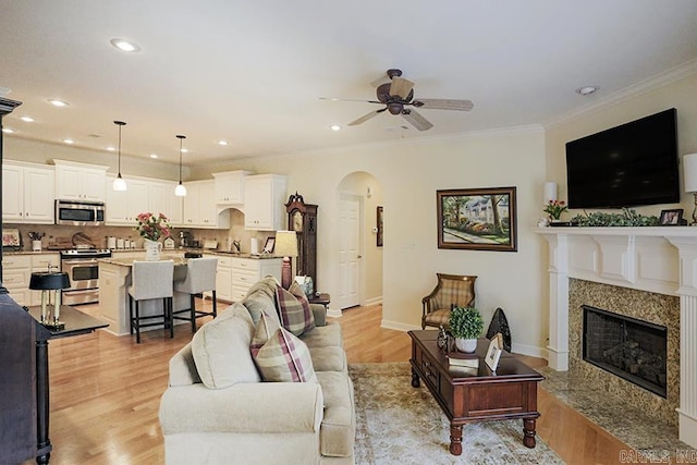 29 Taylor Park Loop, Little Rock, AR 72211 - living room featuring arched walkways, ceiling fan, light wood-type flooring, a high end fireplace, and ornamental molding