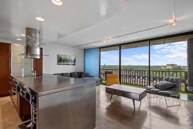 700 E 9th J St Unit 12J, Little Rock, AR 72202 - kitchen with island exhaust hood, a kitchen island, open floor plan, floor to ceiling windows, and black electric cooktop