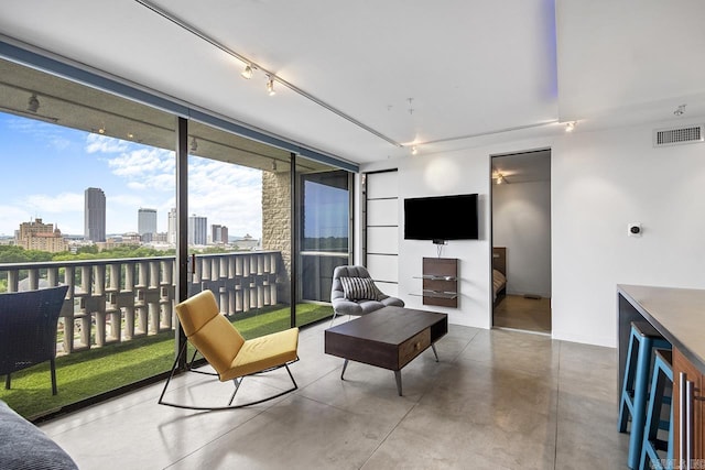 700 E 9th J St Unit 12J, Little Rock, AR 72202 - living area with finished concrete flooring, a city view, track lighting, and a wall of windows
