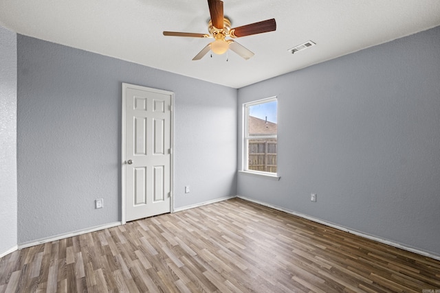 6532 Ridgemist Cv, North Little Rock, AR 72117 - empty room with wood finished floors, a ceiling fan, and a textured wall