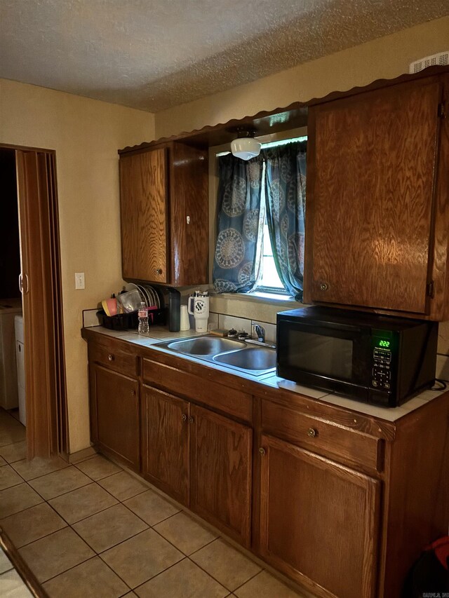 320 S Lewis St, Mineral Sprs, AR 71851 - kitchen with black microwave, light tile patterned flooring, and a textured ceiling