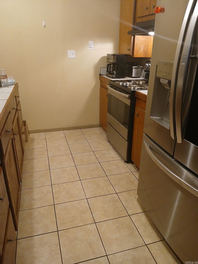 320 S Lewis St, Mineral Sprs, AR 71851 - kitchen featuring appliances with stainless steel finishes, brown cabinets, and light tile patterned flooring