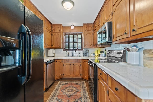 1920 W Arch Ave, Searcy, AR 72143 - kitchen featuring black appliances, tile counters, decorative backsplash, and brown cabinets