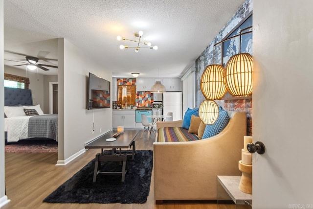 1920 W Arch Ave, Searcy, AR 72143 - living room with wood finished floors, a textured ceiling, a chandelier, and a ceiling fan