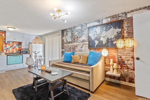 1920 W Arch Ave, Searcy, AR 72143 - living area featuring light wood-style floors, a textured ceiling, a chandelier, and brick wall