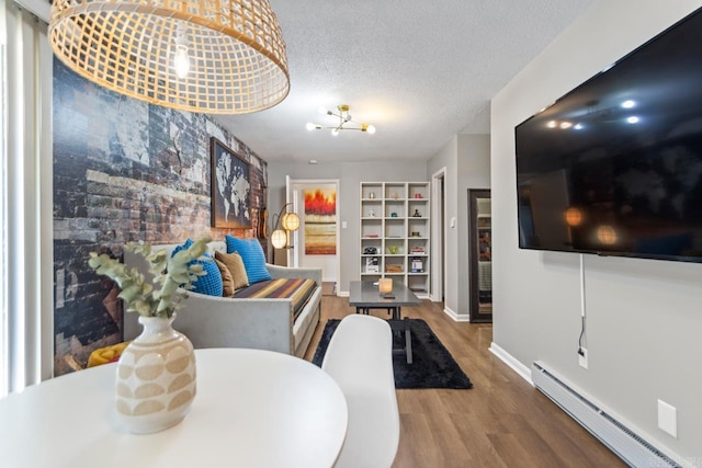 1920 W Arch Ave, Searcy, AR 72143 - living room with a baseboard heating unit, wood finished floors, a textured ceiling, a chandelier, and built in features