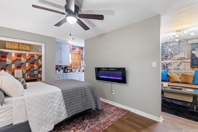 1920 W Arch Ave, Searcy, AR 72143 - bedroom featuring wood finished floors, a glass covered fireplace, and a ceiling fan