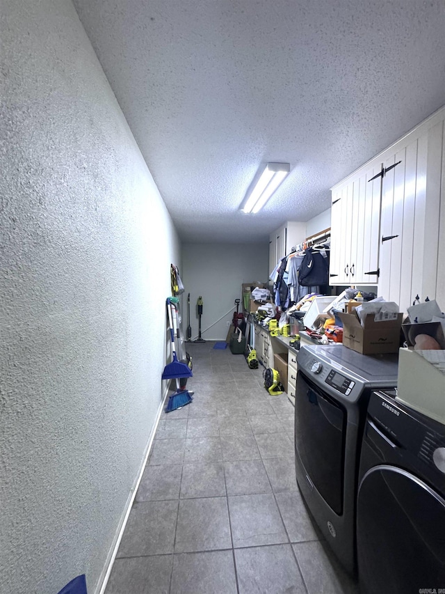 laundry room featuring washer and clothes dryer, cabinet space, a textured wall, a textured ceiling, and light tile patterned flooring