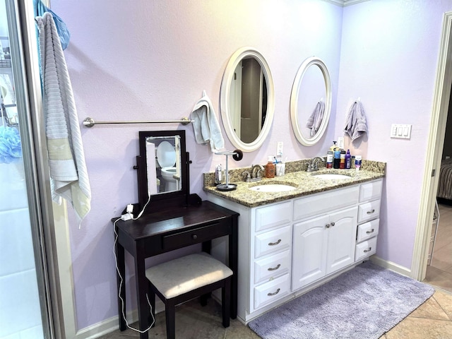 full bathroom featuring double vanity and baseboards