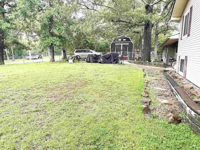 view of yard featuring a storage shed and view of wooded area