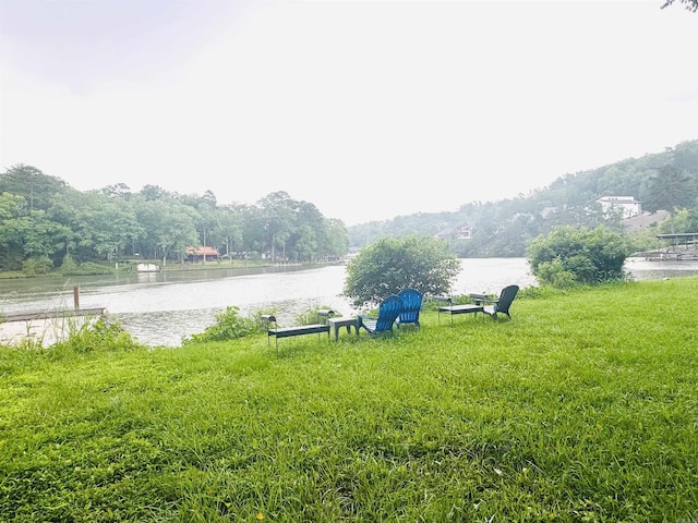 view of green lawn with a water view