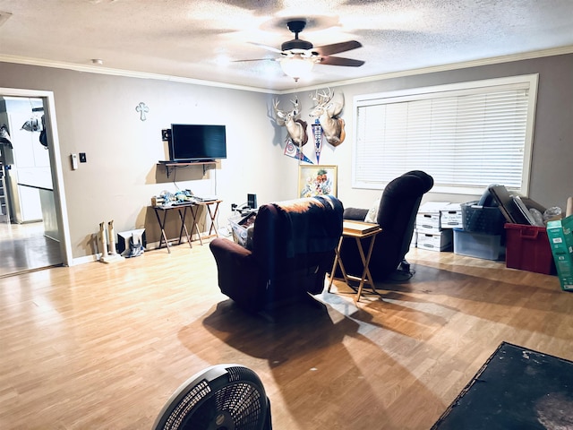 living area featuring wood finished floors, ceiling fan, ornamental molding, an office area, and a textured ceiling
